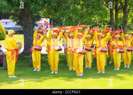 Des membres de Falun Dafa, alias Falun Gong, un mouvement religieux chinois, pratiquant une danse avec des foulards et des tambours de taille. Rotorua, Nouvelle-Zélande, 12/8/2018 Banque D'Images