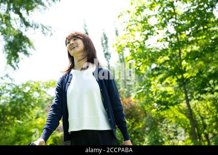 Femme d'âge mûr marchant dans le jardin Banque D'Images