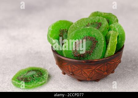 Kiwi séché dans un bol sur fond de béton gris ou de pierre. En-cas sain. Un ingrédient pour préparer des plats sucrés. Baies utiles. Foc sélectif Banque D'Images