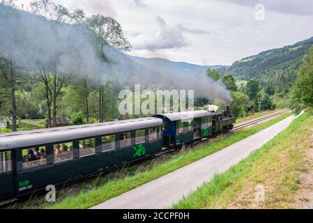 Le train à vapeur touristique 'Murtalbahn' relie les villes de Murau et de Tamsweg en Autriche. Les wagons sont légèrement flous du mouvement des trains. Banque D'Images