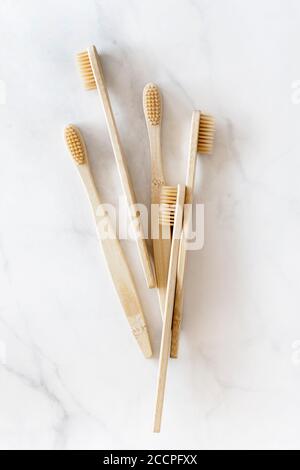 Composition avec brosses à dents en bambou biodégradables sur fond de marbre. Concept durable, zéro déchet, sans plastique, style de vie. Accessoires écologiques pour l'hygiène bucco-dentaire.pose à plat, vue de dessus. Banque D'Images