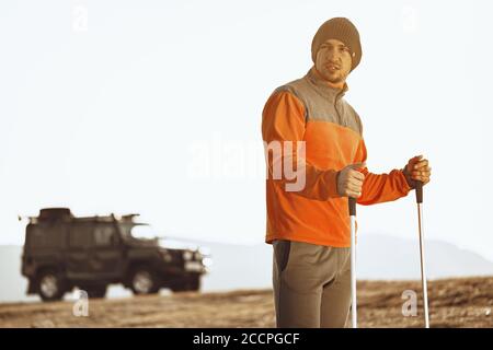 Homme voyageur avec des bâtons de trekking en haut de la montagne Banque D'Images