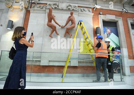 Les baigneurs de soleil, une sculpture de l'artiste hongrois Peter Laszlo Peri retourne à Londres Waterloo après une absence de près de 70 ans. La sculpture, initialement exposée à l'entrée de la station de métro accueillant les visiteurs du Festival de Grande-Bretagne en 1951, a été considérée comme perdue, mais elle a été redécouverte dans le domaine d'un hôtel du sud-est de Londres cassé et peint un rose pâle. Une campagne de financement participatif a permis de recueillir des fonds pour que les couches de peinture soient retirées afin de les restaurer à la couleur terre cuite d'origine embrassée par le soleil. Banque D'Images