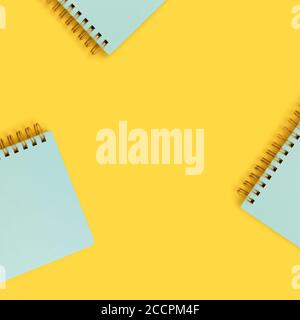 Cadre composé de blocs-notes en spirale de menthe sur fond jaune. Mignons fournitures scolaires. Banque D'Images