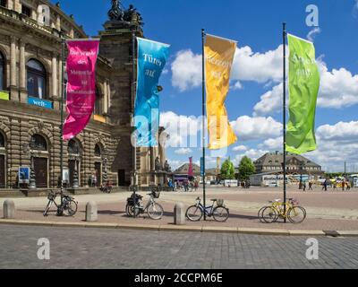 Dresde, Allemagne-7 juin 2017 : vue latérale sur l'Opéra Semper avec le ciel bleu et les nuages blancs. Bannières et vélos colorés au premier plan Banque D'Images