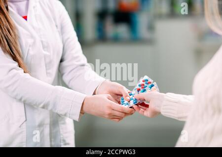 Gros plan d'une fille mains achetant des pilules dans une pharmacie. Banque D'Images