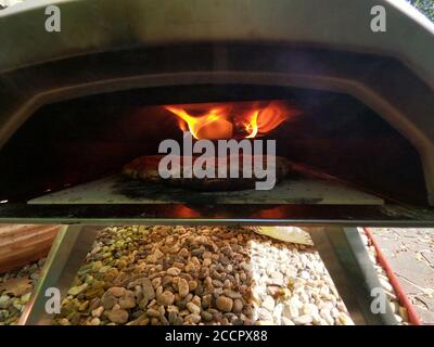 Cuisson de pizza dans un four à bois à la maison avec une pizza peler Banque D'Images