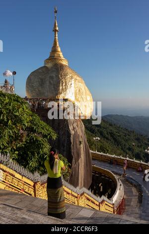 Femme birmane priant devant la Pagode Kyaiktiyo - Golden rock. Elle porte un long-gyi traditionnel. Site de pèlerinage bouddhiste sacré. Mon état, Myanmar Banque D'Images