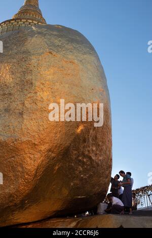 Hommes qui collent des feuilles d'or à la Pagode Kyaiktiyo - Golden rock. Site de pèlerinage bouddhiste sacré. Les femmes ne sont pas autorisées. Pagode Kyaiktiyo, état de mon, Myanmar Banque D'Images