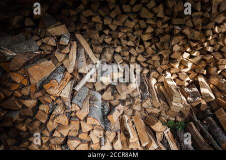 Stock de bois de chauffage, cales en bois empilées dans une grange rurale Banque D'Images
