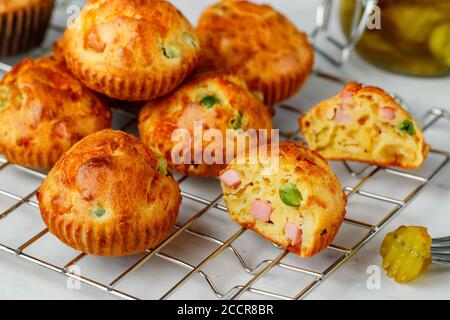 Délicieux muffins maison fraîchement préparés avec parmesan, saucisses ou jambon et petits pois. Hors-d'œuvre gastronomique. Mise au point sélective Banque D'Images