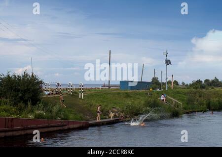 BELOZERSK, RUSSIE - 03 août 2020, Embankment dans la ville de Belozersk. Région de Vologda. Les garçons nagent dans un canal près du lac Banque D'Images