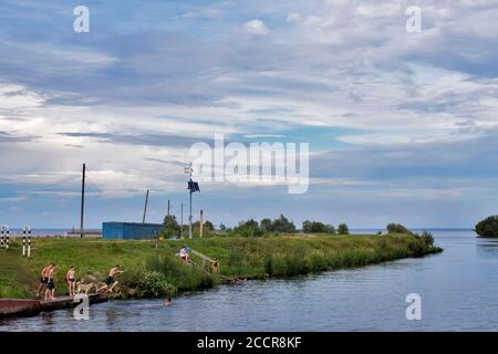 BELOZERSK, RUSSIE - 03 août 2020, Embankment dans la ville de Belozersk. Région de Vologda. Les garçons nagent dans un canal près du lac Banque D'Images