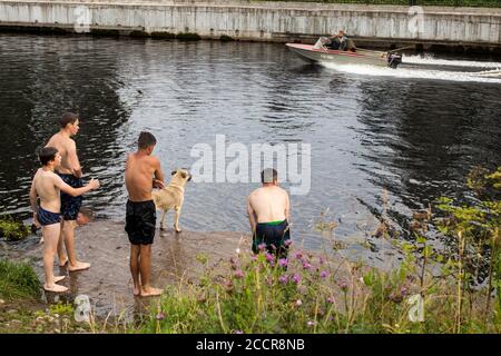 BELOZERSK, RUSSIE - 03 août 2020, Embankment dans la ville de Belozersk. Région de Vologda. Les garçons nagent dans un canal près du lac Banque D'Images