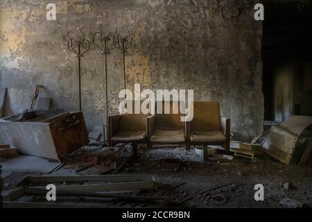 De vieux chaises ruinées dans une école abandonnée à Pripyat, zone d'exclusion de Tchernobyl, en Ukraine Banque D'Images