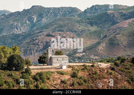 12ème église de San Michele à Murato en Corse avec montagnes derrière Banque D'Images