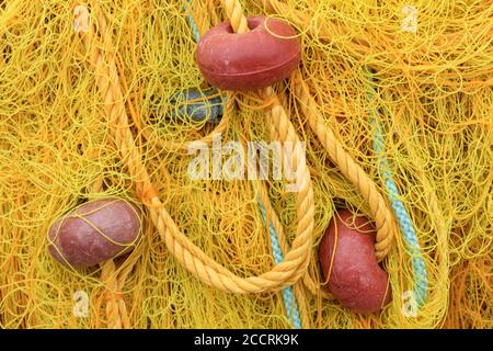 Filet de pêche jaune avec bouées rouges entassé sur le port Banque D'Images