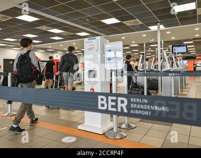 24 août 2020, Brandebourg, Schönefeld : les voyageurs se rendent à l'enregistrement dans le bâtiment du terminal T5 de l'aéroport de Berlin-Schönefeld. Le même jour, une tournée de presse a eu lieu au terminal T5. Avec l'ouverture de l'aéroport de Berlin Brandenburg (BER), l'aéroport de Schoenefeld fera partie de BER en tant que terminal T5. Photo: Patrick Pleul/dpa-Zentralbild/ZB Banque D'Images