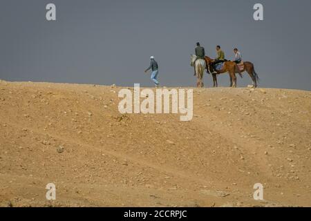 Égypte. Avril 2019. Hommes à cheval au sommet d'une dune dans les pyramides de Gizeh. Banque D'Images