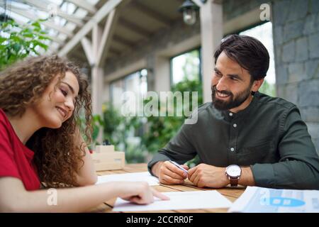 Jeune homme et femme assis à l'intérieur dans le bureau, concept de réunion d'affaires. Banque D'Images
