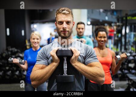 Groupe de jeunes amis qui font des exercices en salle de gym Banque D'Images