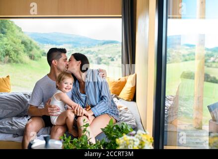 Jeune famille avec petite fille à l'intérieur, week-end loin dans la maison de conteneurs dans la campagne. Banque D'Images