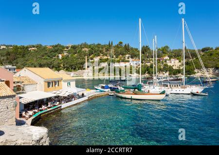 Taverne en bord de mer et bateaux au port de Longos, Paxos, Iles Ioniennes, Grèce Banque D'Images