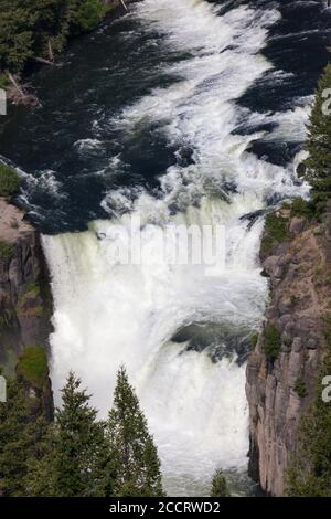 Lower Mesa Falls dans l'Idaho le long de Mesa Falls Scenic Byway sur une journée ensoleillée avec sauvage et rapide eau en cascade sur les falaises rocheuses avec les environs Banque D'Images