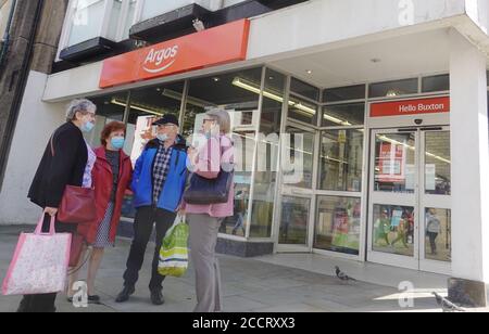 Quatre personnes en dehors d'Argos à Buxton, Derbyshire, portent toutes un masque facial pour aider à prévenir la propagation du coronavirus, qui est dans le pays depuis au moins cinq mois. Banque D'Images