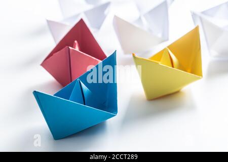 Bateaux en papier multicolores. Concept de bateaux de leadership pour le travail d'équipe de groupe ou de succès Banque D'Images