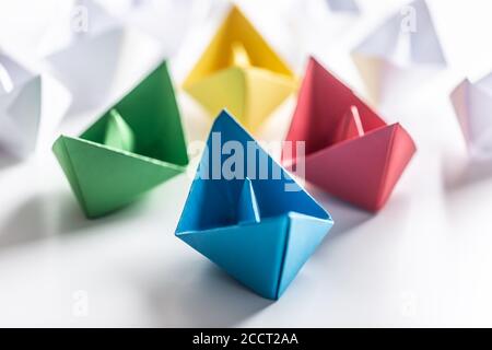 Bateaux en papier multicolores. Concept de bateaux de leadership pour le travail d'équipe de groupe ou de succès Banque D'Images