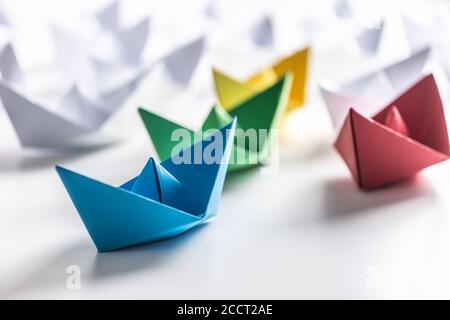 Bateaux en papier multicolores. Concept de bateaux de leadership pour le travail d'équipe de groupe ou de succès Banque D'Images