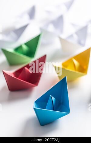 Bateaux en papier multicolores. Concept de bateaux de leadership pour le travail d'équipe de groupe ou de succès Banque D'Images