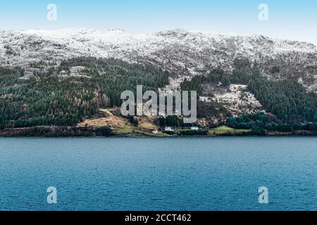 Des montagnes enneigées le long de la côte de Norvège, en Scandinavie. Banque D'Images
