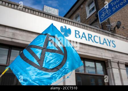 Drapeau de la rébellion d'extinction bleue à l'extérieur de la Barclays Bank à Balham, dans le sud de Londres. XR continue de protester contre Barclays pour crimes contre la planète. Banque D'Images