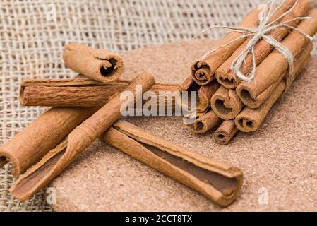 Bâtonnets de cannelle, écorce de cannelle sèche attachée dans un bouquet sur un fond de toile de fond. Banque D'Images