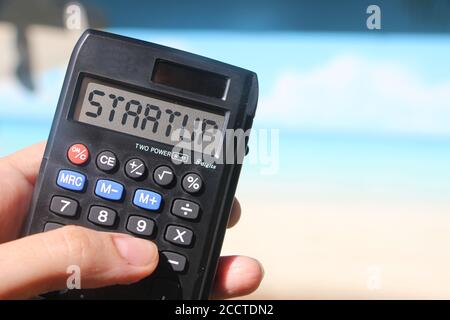 Démarrage par mot sur l'écran de la calculatrice, paysage de plage. Nouveau concept d'entreprise Banque D'Images