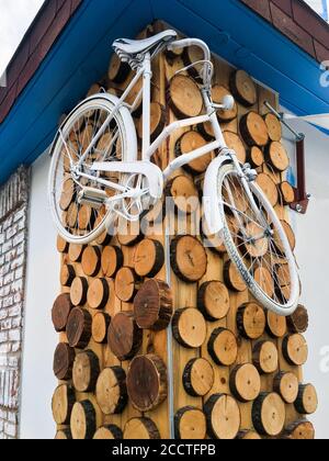 Vélo blanc suspendu sur le mur en bois. Décoration spéciale. Banque D'Images