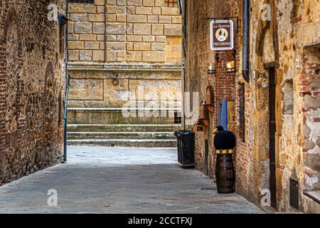 Une ruelle étroite mène à la fromagerie La Taverna del Pecorino dans la vieille ville de Pienza, en Toscane, en Italie, réputée pour son fromage de lait de brebis, le Pecorino di Pienza. Banque D'Images
