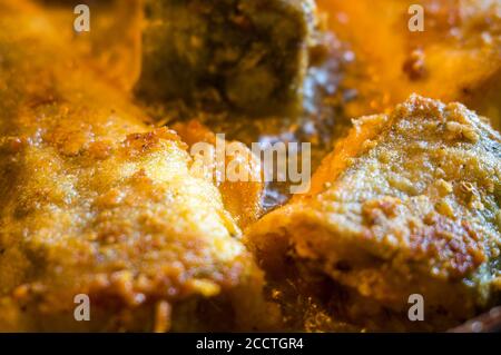 Morceaux de poisson navaga en pâte, frits dans l'huile dans une casserole. Banque D'Images