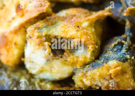 Morceaux de poisson navaga en pâte, frits dans l'huile dans une casserole. Banque D'Images