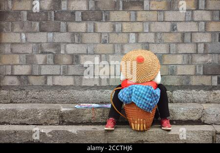 Fenghuang, Chine - 15 mai 2017 : une femme se repose dans la rue dans la ville de Phoenix Fenghuang Banque D'Images