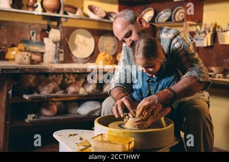 Atelier de poterie. Grand-père-fille enseigne la poterie. Modelage Banque D'Images