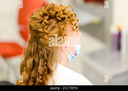 bonne jeune femme et coiffeur avec fer à repasser à faire coiffer au salon de coiffure. Femme ayant un coiffeur stylisé. Permet de lisser le gondolage des cheveux. Styliste U Banque D'Images