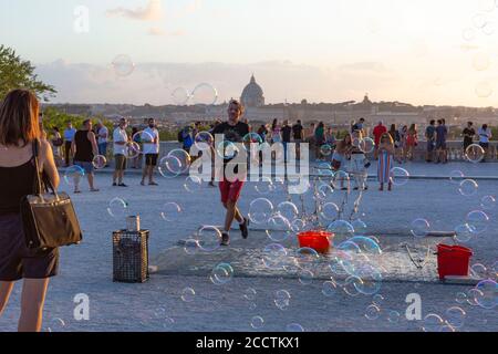 Rome, Italie, le 24 août 2020. Les gens prennent des photos et posent pour des photos contre un nuage de bulles de savon créé par un interprète de rue au Pincio à Villa Borghese, Rome, une terrasse populaire avec une vue sur le dôme de Saint Peters et le coucher de soleil sur la ville Credit: Stephen Bisgrove/Alay Live News Banque D'Images