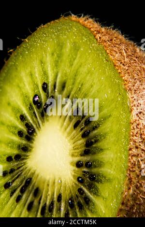 Gros plan d'une tranche de kiwi, couleur verte luxuriante, fraîcheur Banque D'Images