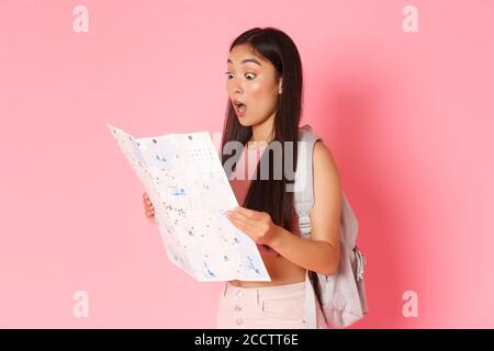 Concept de voyage, de style de vie et de tourisme. Portrait d'une petite fille asiatique stupéfait touriste en vacances, voyage avec sac à dos, regardant surpris à la carte Banque D'Images