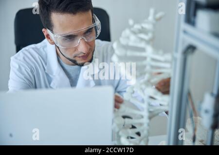 Étudiant en médecine assis à un bureau dans un laboratoire Banque D'Images