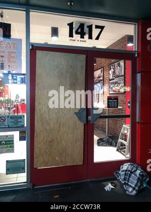 Seattle, États-Unis - 10 mai 2020 : tard dans la journée, une porte de verre à buttes au restaurant du centre-ville pendant la pandémie de fermeture Covid-19. Banque D'Images