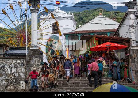 Des danseurs costumés dans les masques descendent les escaliers devant De l'église de Santiago à jouer pour le Festival De Santiago dans le marché ouvert de Santia Banque D'Images